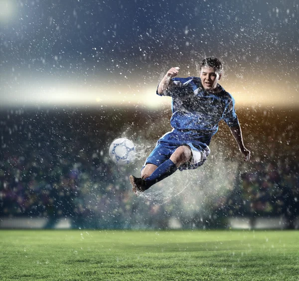 Jogador de futebol golpeando a bola — Fotografia de Stock