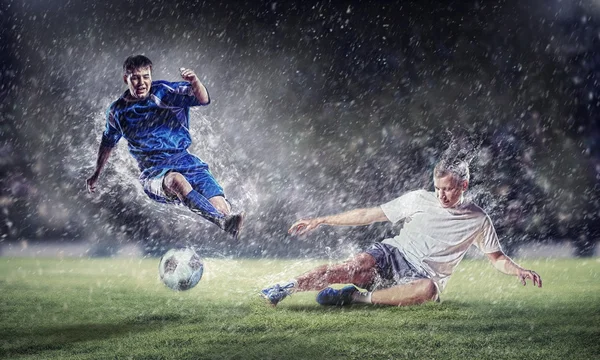 Två fotbollsspelare slående bollen — Stockfoto