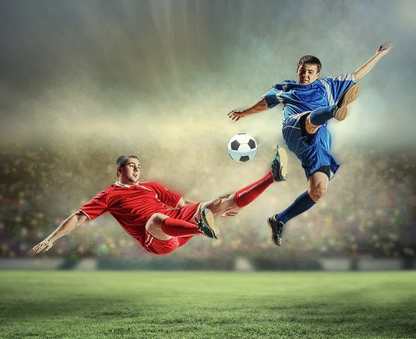 Two football players striking the ball — Stock Photo, Image