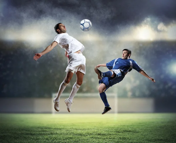 Dois jogadores de futebol golpeando a bola — Fotografia de Stock