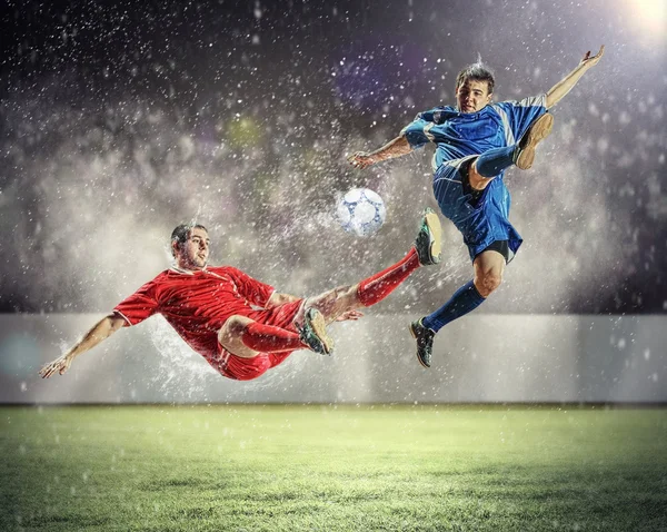 Two football players striking the ball — Stock Photo, Image