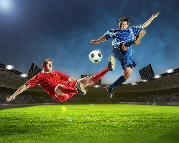 Dois jogadores de futebol golpeando a bola — Fotografia de Stock