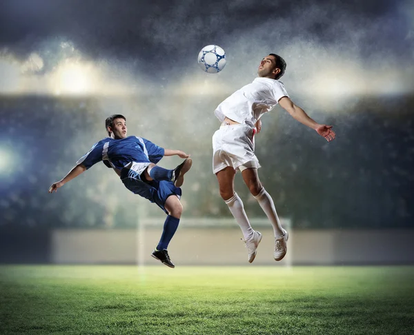 Two football players striking the ball — Stock Photo, Image