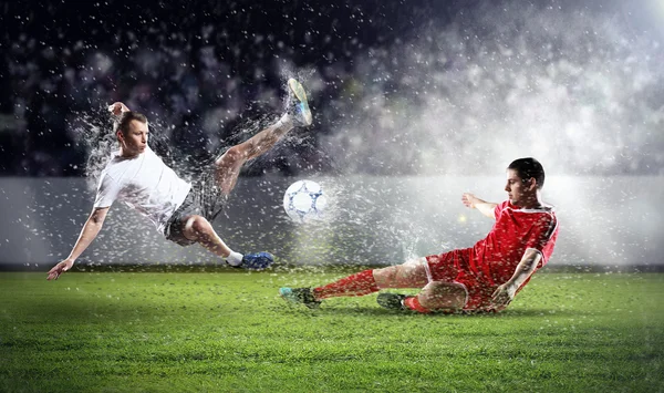 Två fotbollsspelare slående bollen — Stockfoto