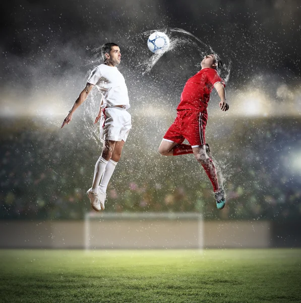 Two football players striking the ball — Stock Photo, Image