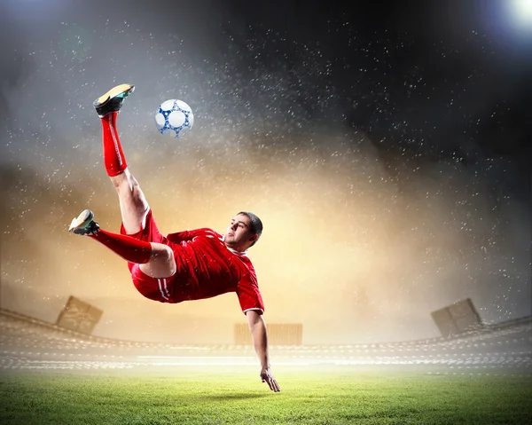 Футболист бьет по мячу — стоковое фото