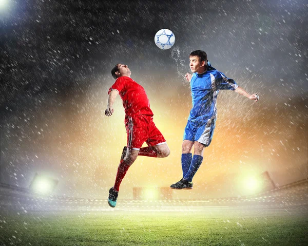 Two football players striking the ball — Stock Photo, Image