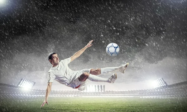 Jogador de futebol golpeando a bola — Fotografia de Stock