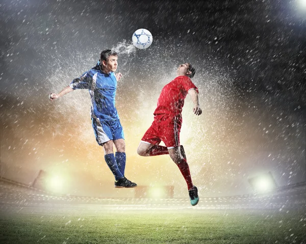 iki futbol oyuncu topu çarpıcı