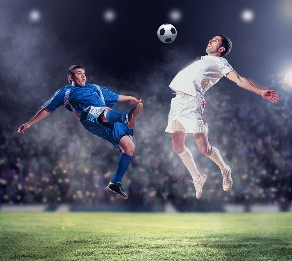 Two football players striking the ball — Stock Photo, Image