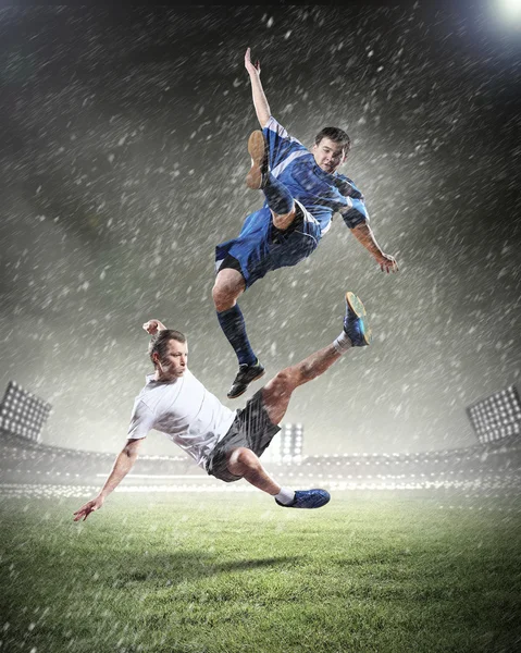 Dwóch piłkarzy uderzając piłkę — Zdjęcie stockowe
