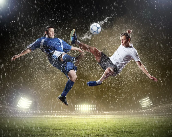 Två fotbollsspelare slående bollen — Stockfoto