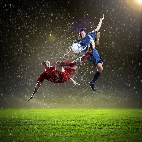 Two football players striking the ball — Stock Photo, Image