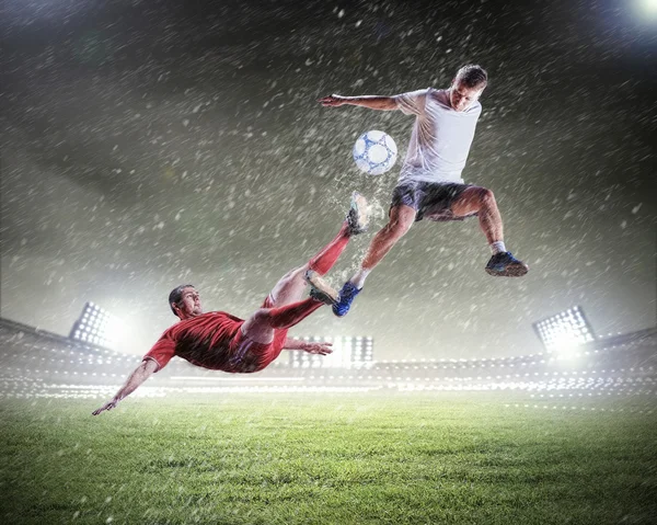 Deux joueurs de football frappant le ballon — Photo