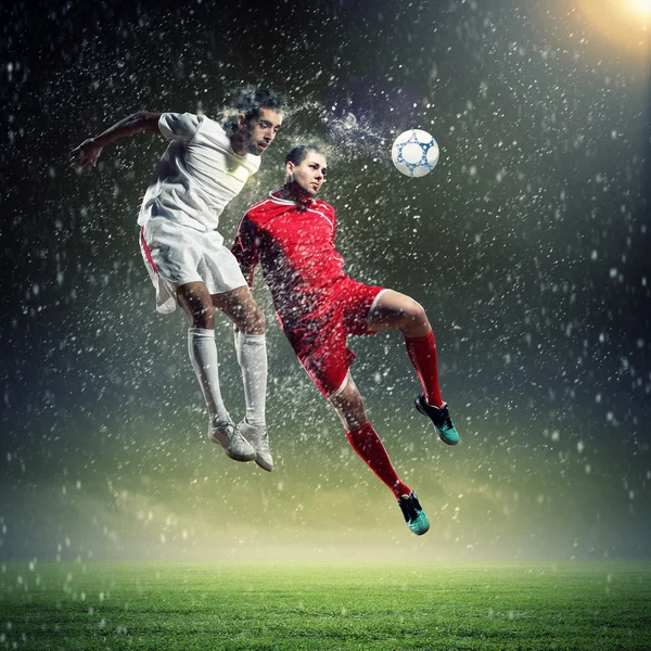 Two football players striking the ball — Stock Photo, Image