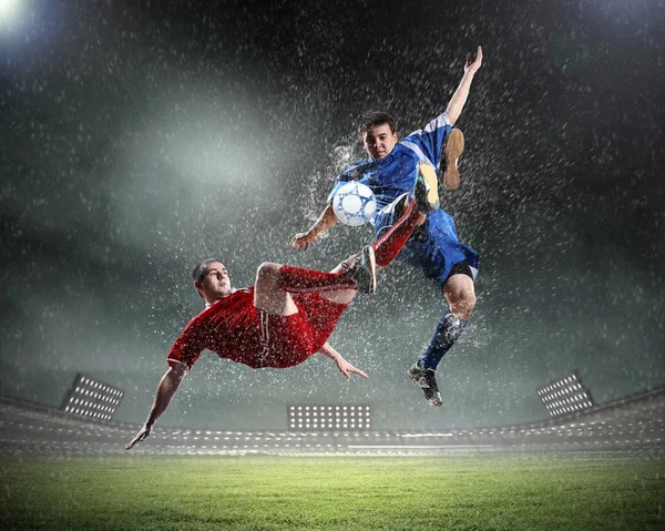 Två fotbollsspelare slående bollen — Stockfoto