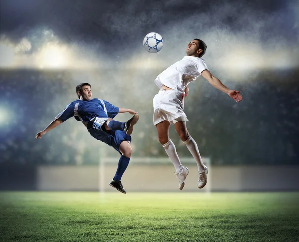 Dois jogadores de futebol golpeando a bola — Fotografia de Stock