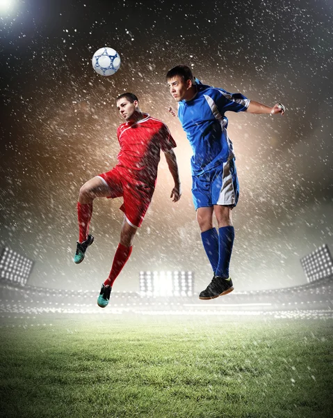 Dois jogadores de futebol golpeando a bola — Fotografia de Stock