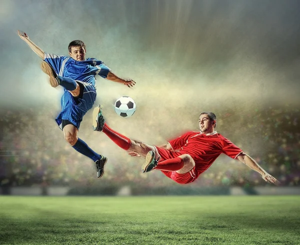 Dois jogadores de futebol golpeando a bola — Fotografia de Stock