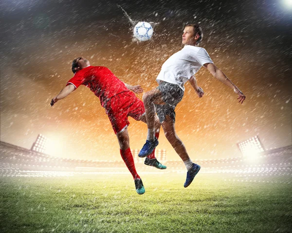 Two football players striking the ball — Stock Photo, Image