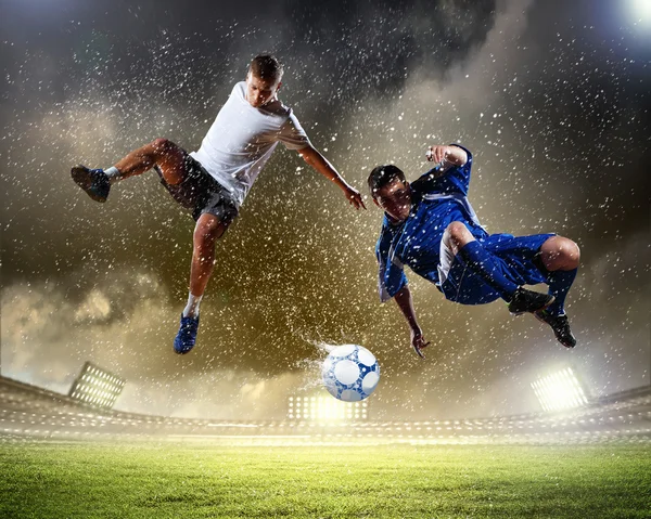 Dos jugadores de fútbol golpeando la pelota — Foto de Stock