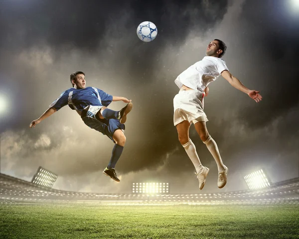 Two football players striking the ball — Stock Photo, Image