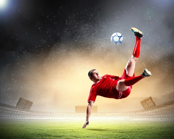 Jogador de futebol golpeando a bola — Fotografia de Stock