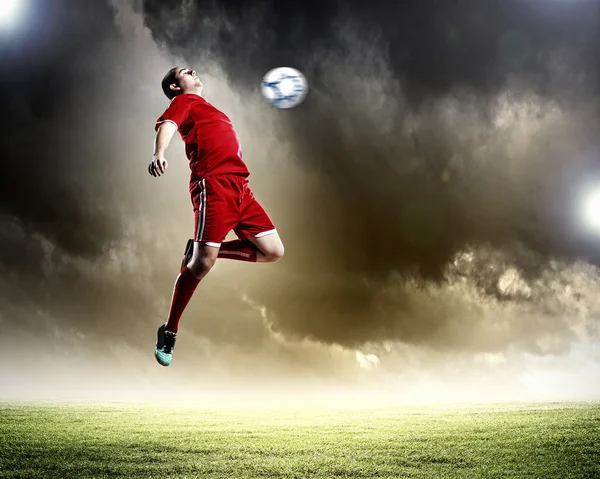 Jogador de futebol golpeando a bola — Fotografia de Stock