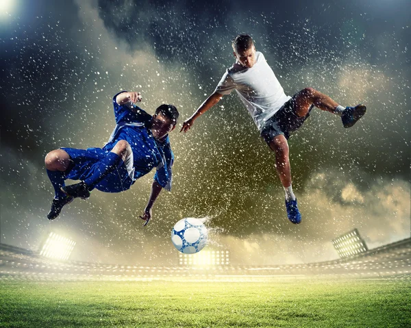 Dois jogadores de futebol golpeando a bola — Fotografia de Stock