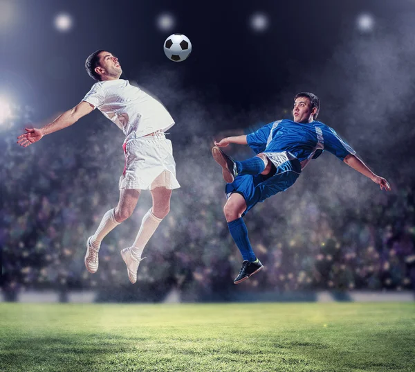 Two football players striking the ball — Stock Photo, Image