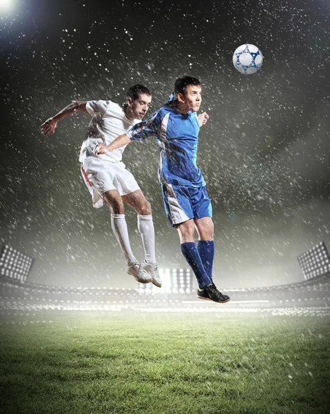 Two football players striking the ball — Stock Photo, Image