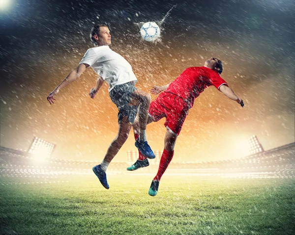 Dois jogadores de futebol golpeando a bola — Fotografia de Stock