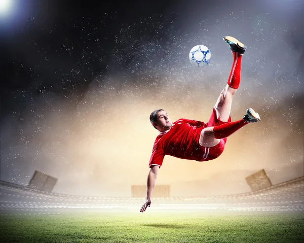 Jogador de futebol golpeando a bola — Fotografia de Stock