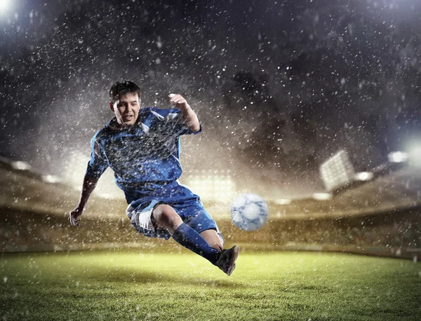 Jogador de futebol golpeando a bola — Fotografia de Stock