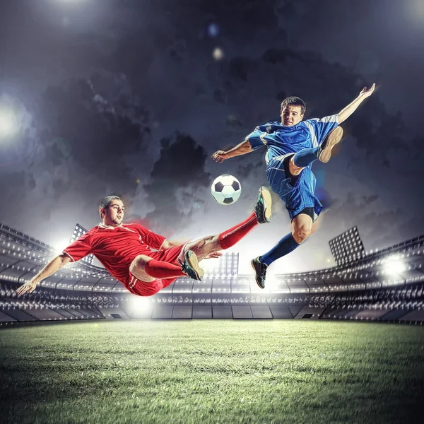 Dois jogadores de futebol golpeando a bola — Fotografia de Stock