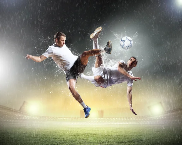 Deux joueurs de football frappant le ballon — Photo