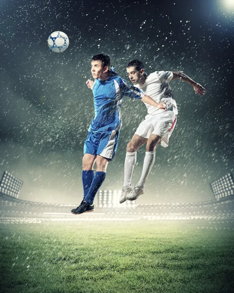 Two football players striking the ball — Stock Photo, Image