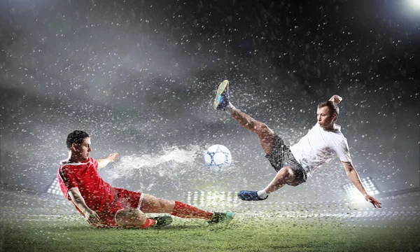 Dos jugadores de fútbol golpeando la pelota — Foto de Stock