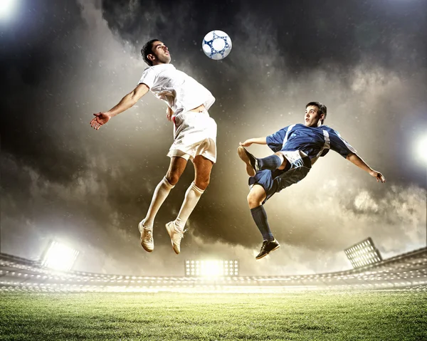 Two football players striking the ball — Stock Photo, Image