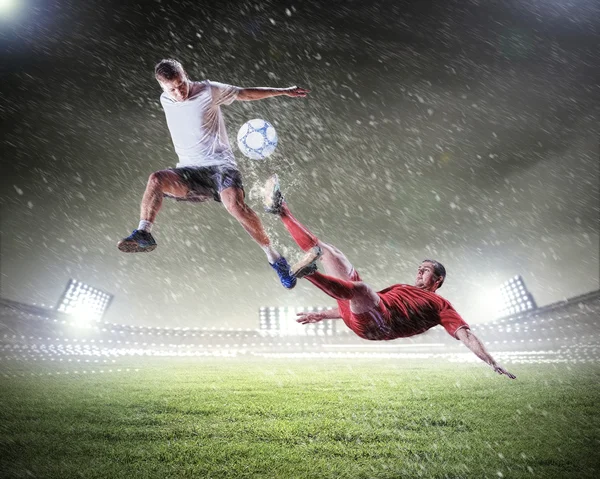 Two football players striking the ball — Stock Photo, Image