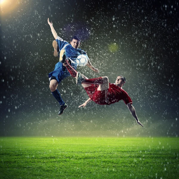 Två fotbollsspelare slående bollen — Stockfoto