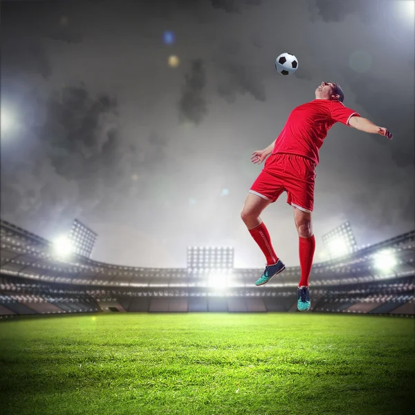 Jogador de futebol golpeando a bola — Fotografia de Stock