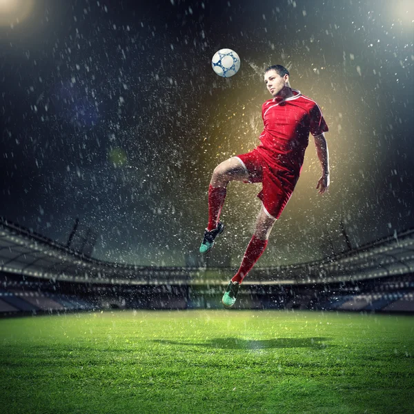 Jogador de futebol golpeando a bola — Fotografia de Stock