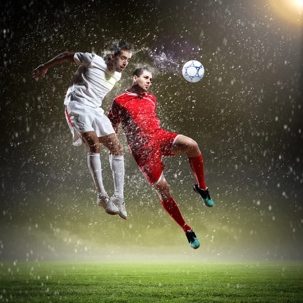 Due giocatori di calcio che colpiscono la palla — Foto Stock