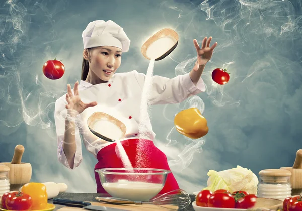 Asian female cooking with magic — Stock Photo, Image