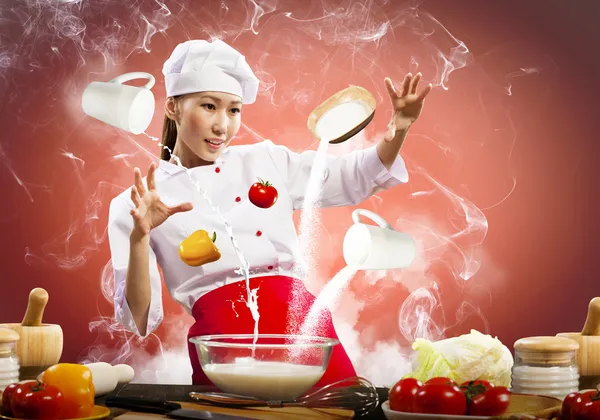 Asian female cooking with magic — Stock Photo, Image