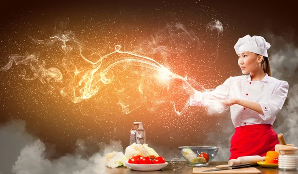 Asiática fêmea cozinhar com magia — Fotografia de Stock