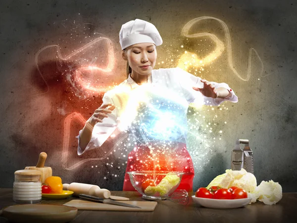 Asian female cooking with magic — Stock Photo, Image