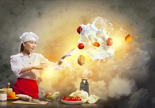 Asian female cooking with magic — Stock Photo, Image
