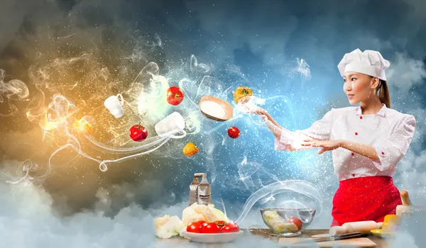 Asian female cooking with magic — Stock Photo, Image